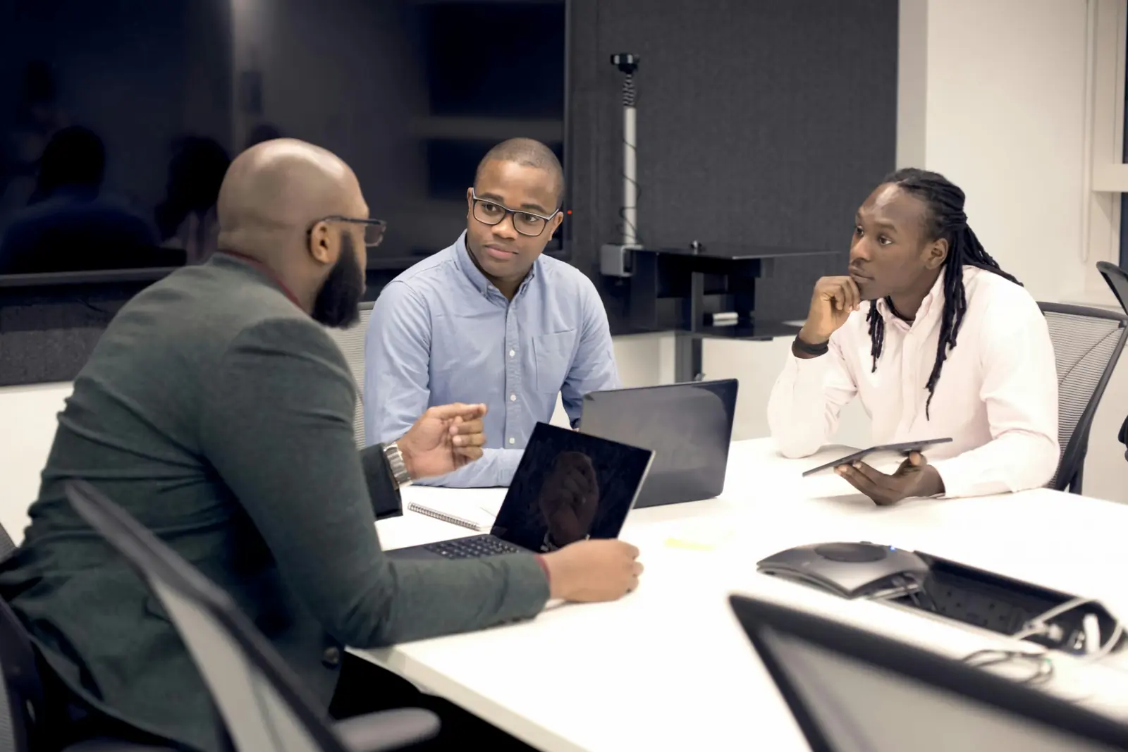 Three consultants discussing a plan around a meeting table